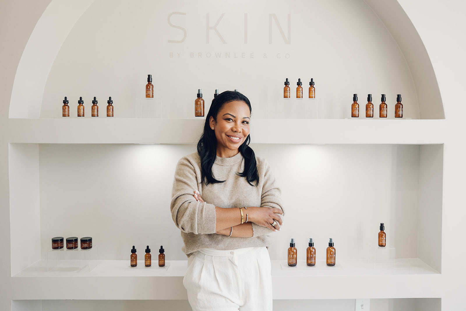 Sylvia Brownlee standing in front of the SKIN by Brownlee & Co. product wall